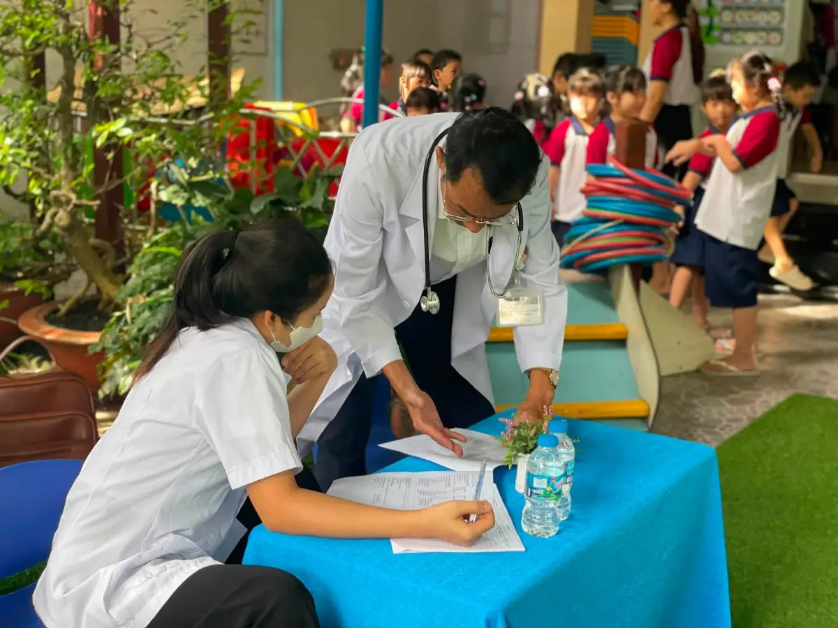 Nhân viên y tế ghi nhận thông tin khám sức khỏe của bé