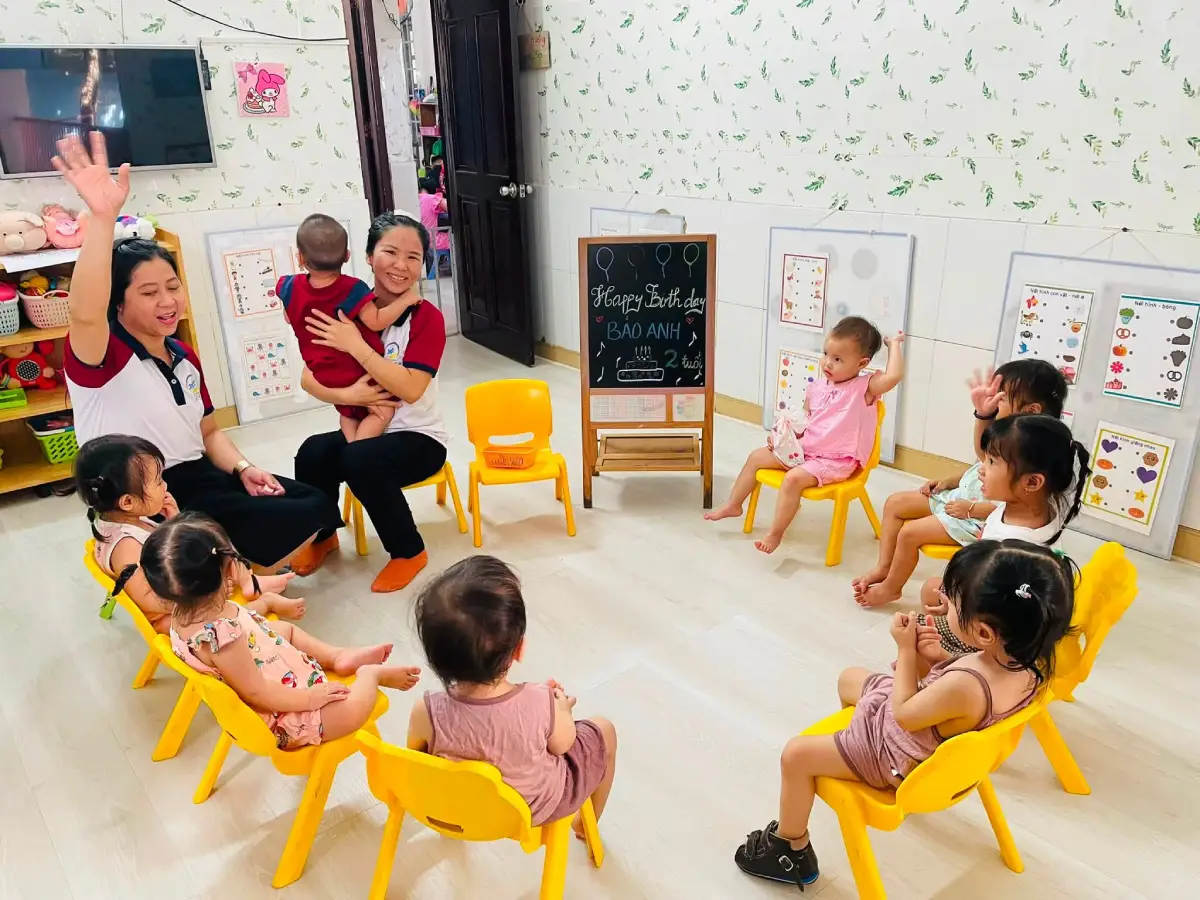 Bé Bảo Anh mỉm cười bên bảng chúc mừng sinh nhật 2 tuổi