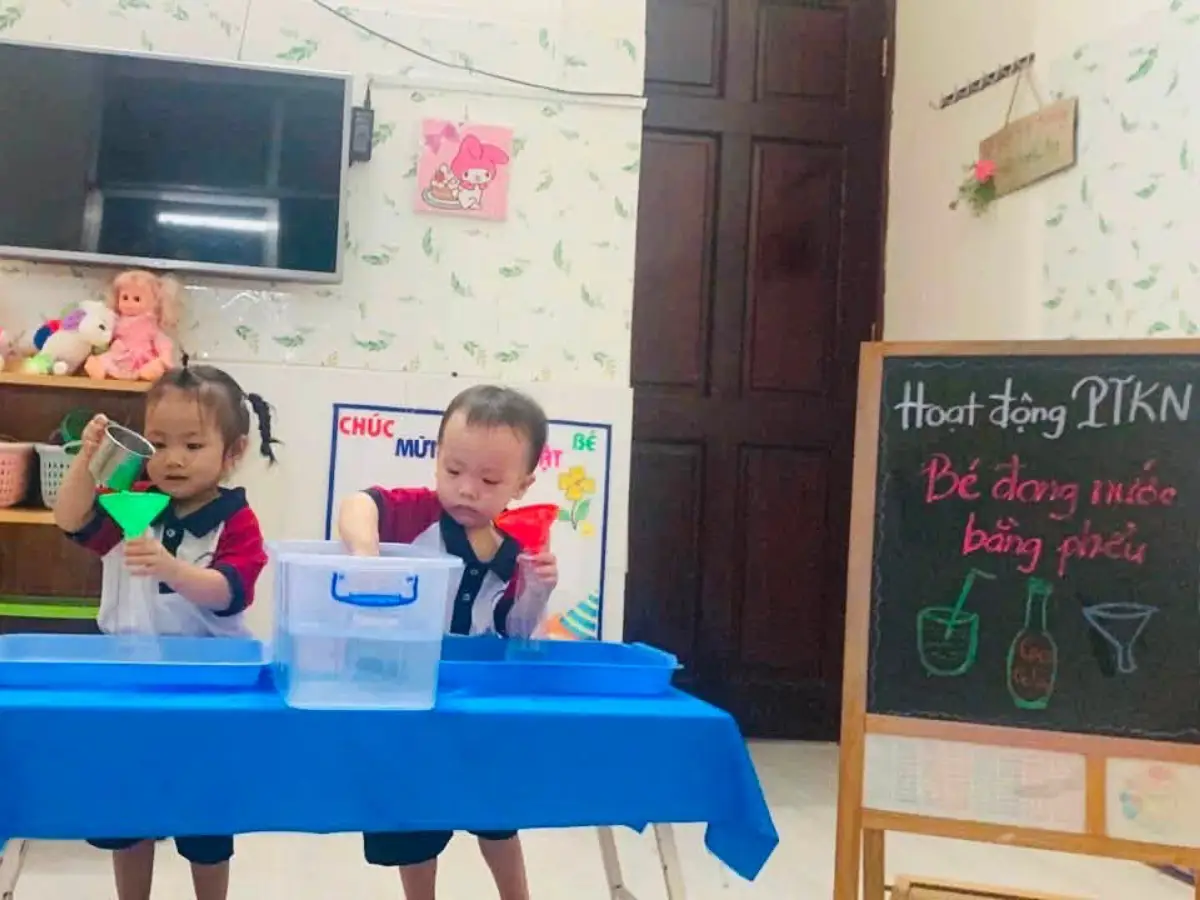 Bé lớp Sóc Nâu thực hành rót nước qua phễu