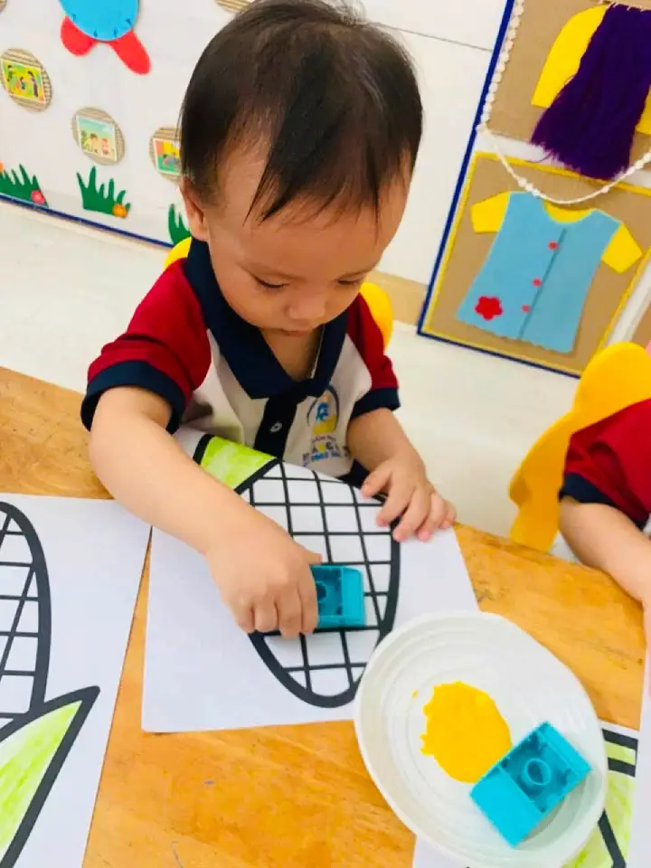 Các bé lớp Sóc Nâu quan sát cô hướng dẫn bài tạo hình bắp ngô