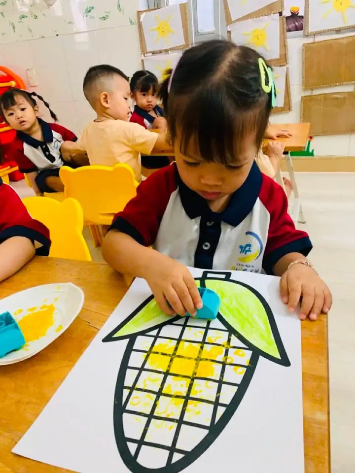 Bé lớp Sóc Nâu tô màu nước lên hình bắp ngô